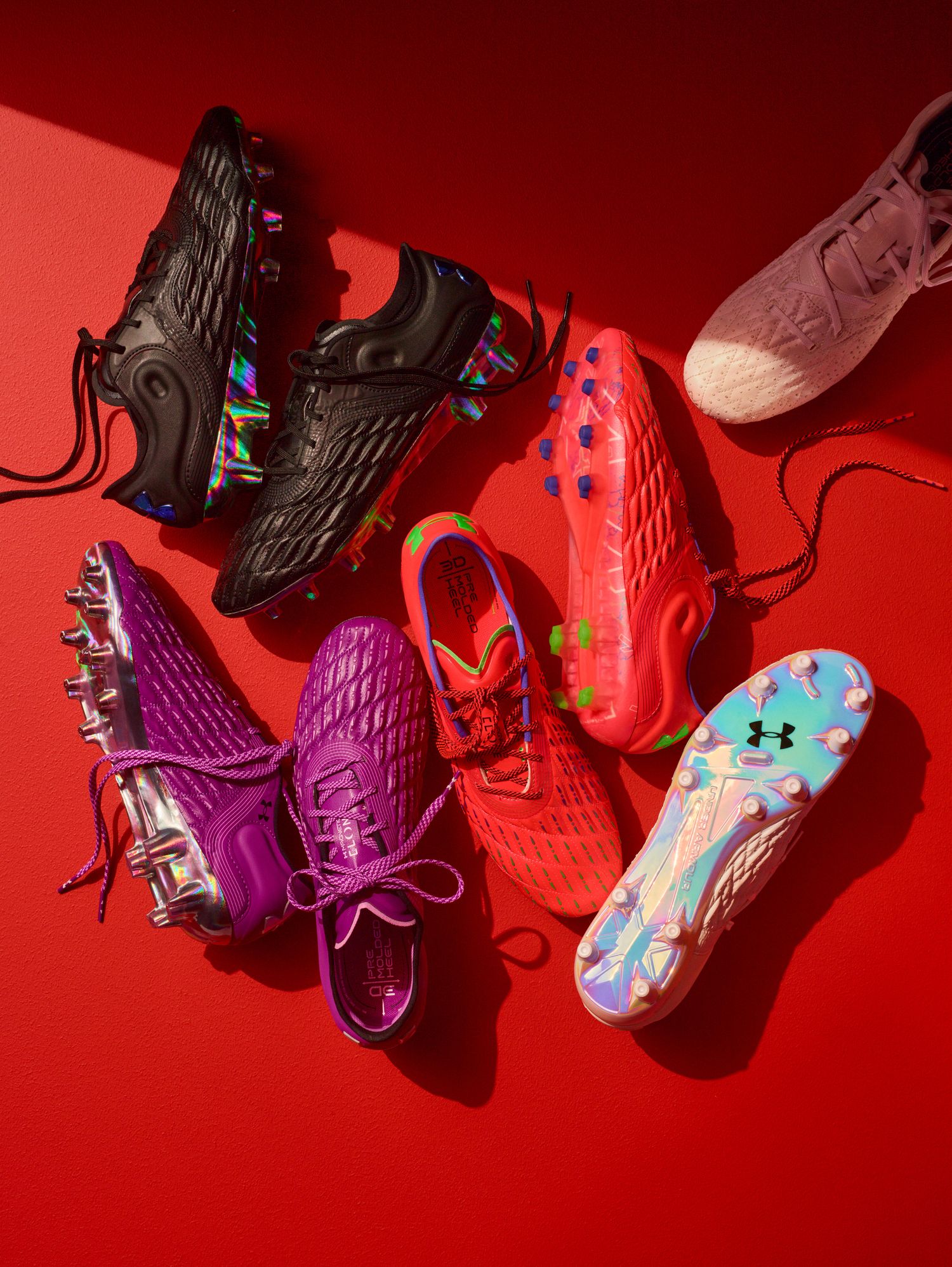 Side view of multiple Under Armour soccer cleats.